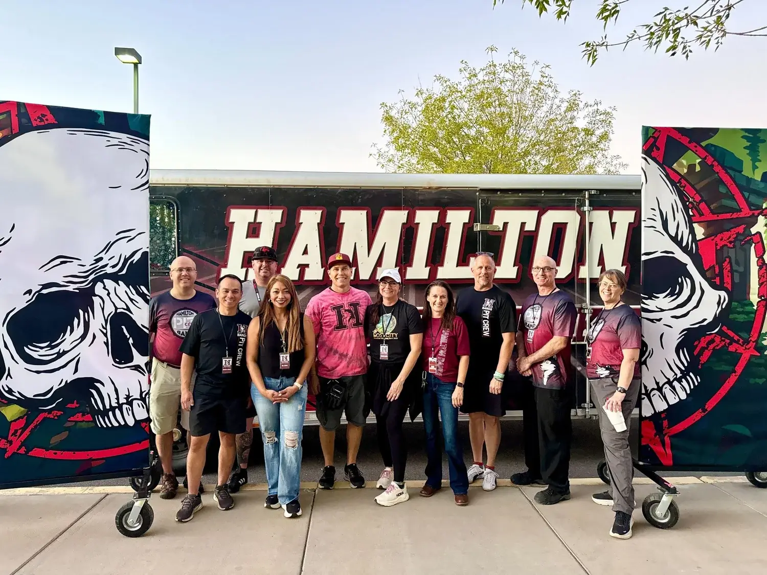 Hamilton Band Booster pit crew volunteers in front of the band equipment trailer