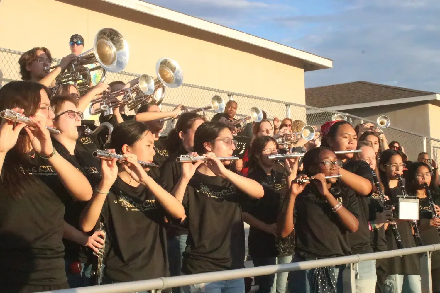Hamilton flutes and brass playing in the stands at sunset